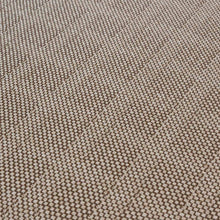 Load image into Gallery viewer, Close-up of the Osiris carpet by New Weave, a circular beige jacquard woven rug made with ECONYL® regenerated nylon and a subtle geometric pattern.