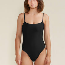 Charger l'image dans la galerie, Woman wearing a black bikini crafted from ECONYL® nylon against a beige background