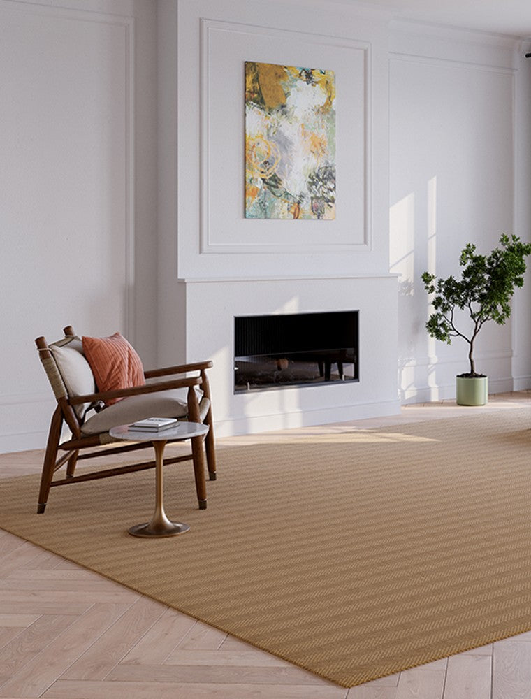 A stylish rug by Synsisal, made from ECONYL® regenerated nylon, in a living room setting with a fireplace, wooden rocking chair, and potted plant.