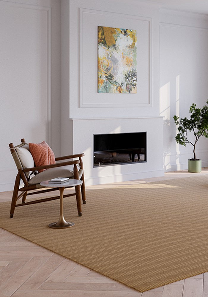 A stylish rug by Synsisal, made from ECONYL® regenerated nylon, in a living room setting with a fireplace, wooden rocking chair, and potted plant.