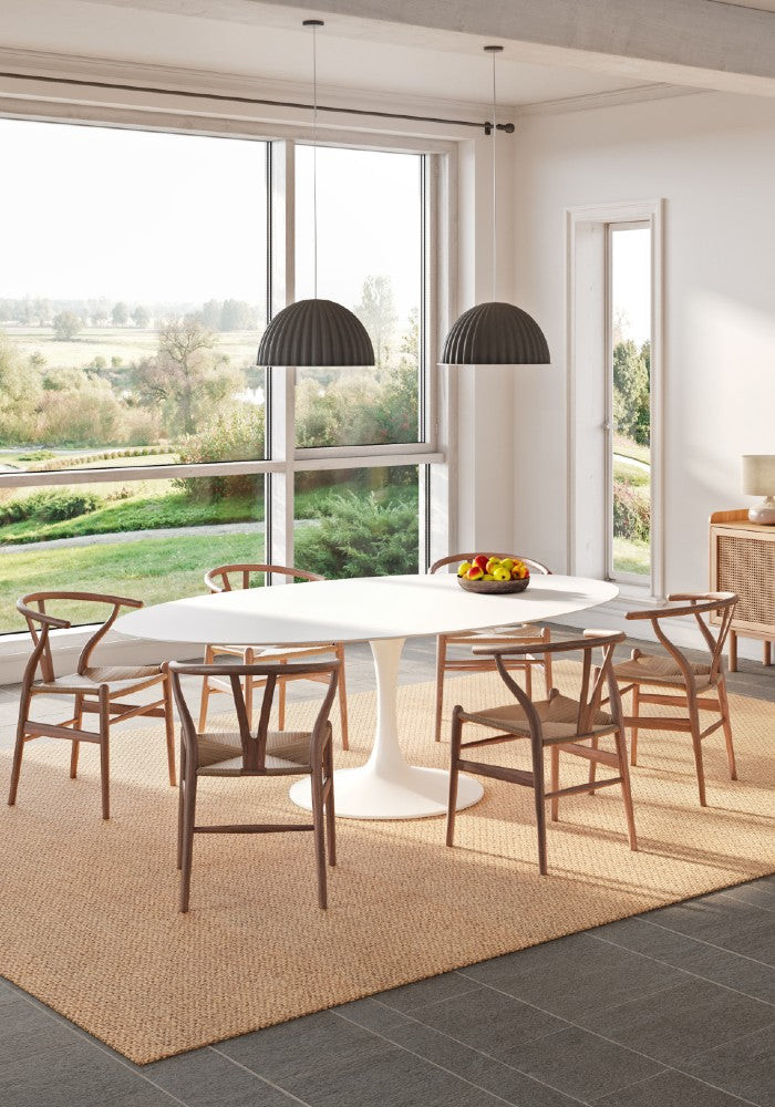 Modern living room with a beige SynSisal weave rug, a white table in the center, a pendant light, and a window overlooking a green field.