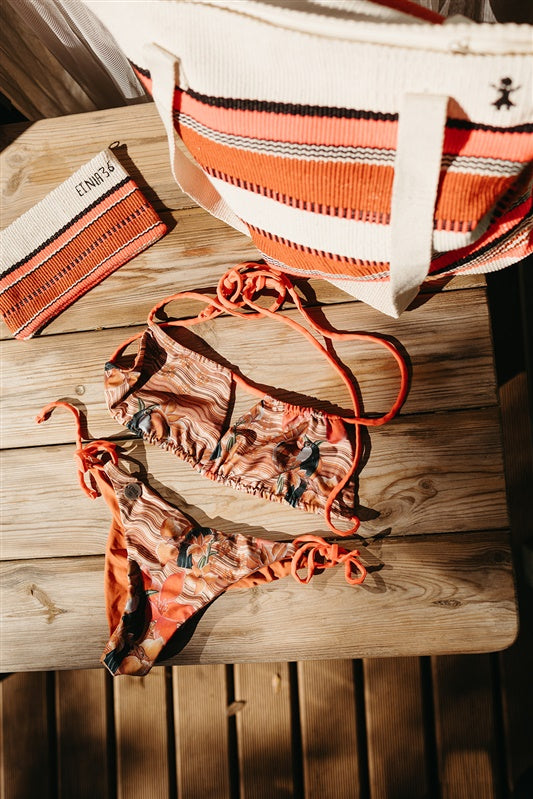 An orange and beige patterned string bikini crafted with ECONYL® regenerated nylon