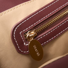 Charger l'image dans la galerie, Close-up of a beige and burgundy bag, featuring ECONYL® regenerated nylon, with a gold zipper and 'Chantecler' tag. 
