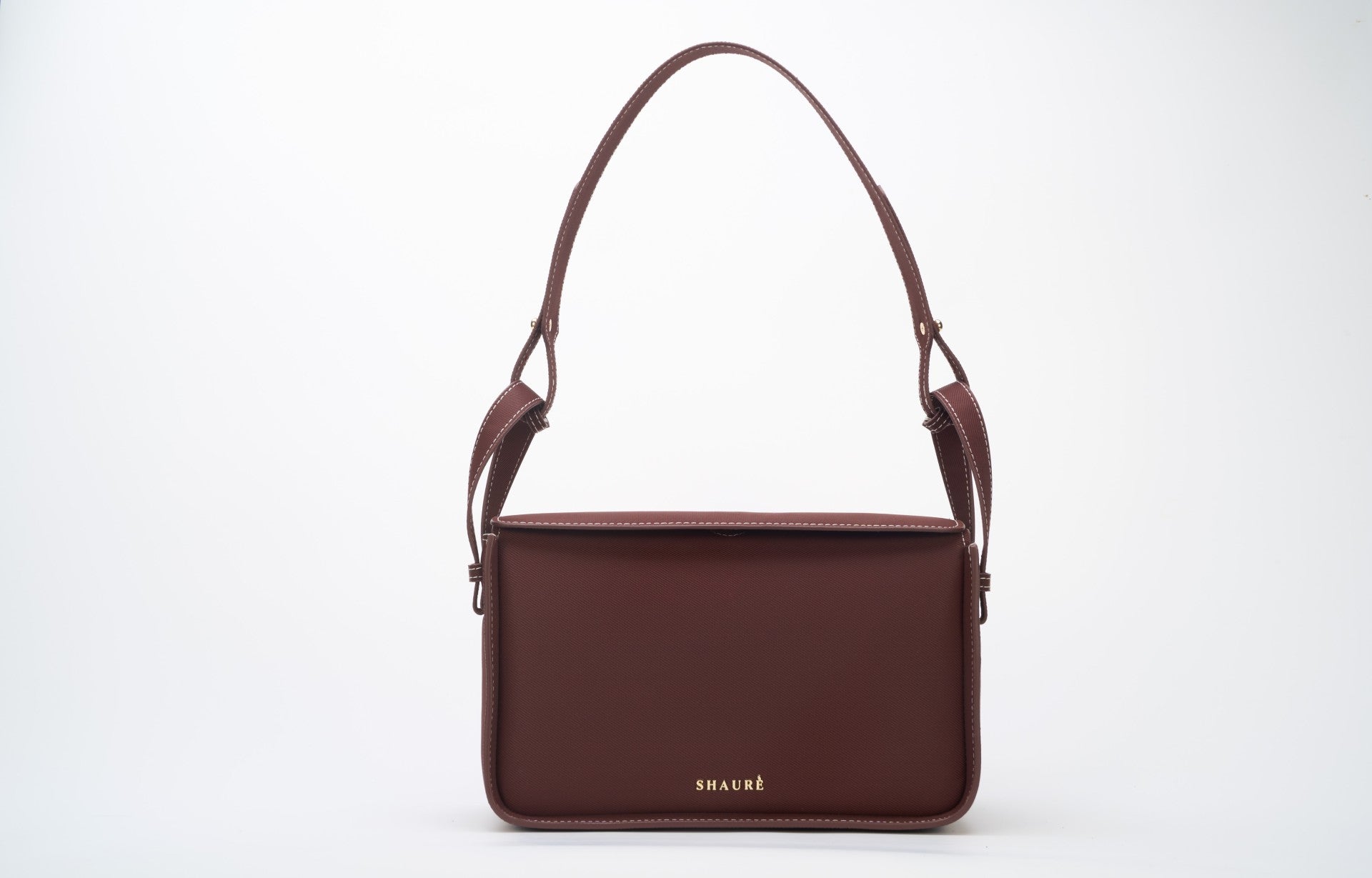 Conscious brown crossbody bag featuring ECONYL® regenerated nylon, isolated on white.