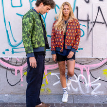 Load image into Gallery viewer, Two people standing in front of a graffiti-covered wall.
