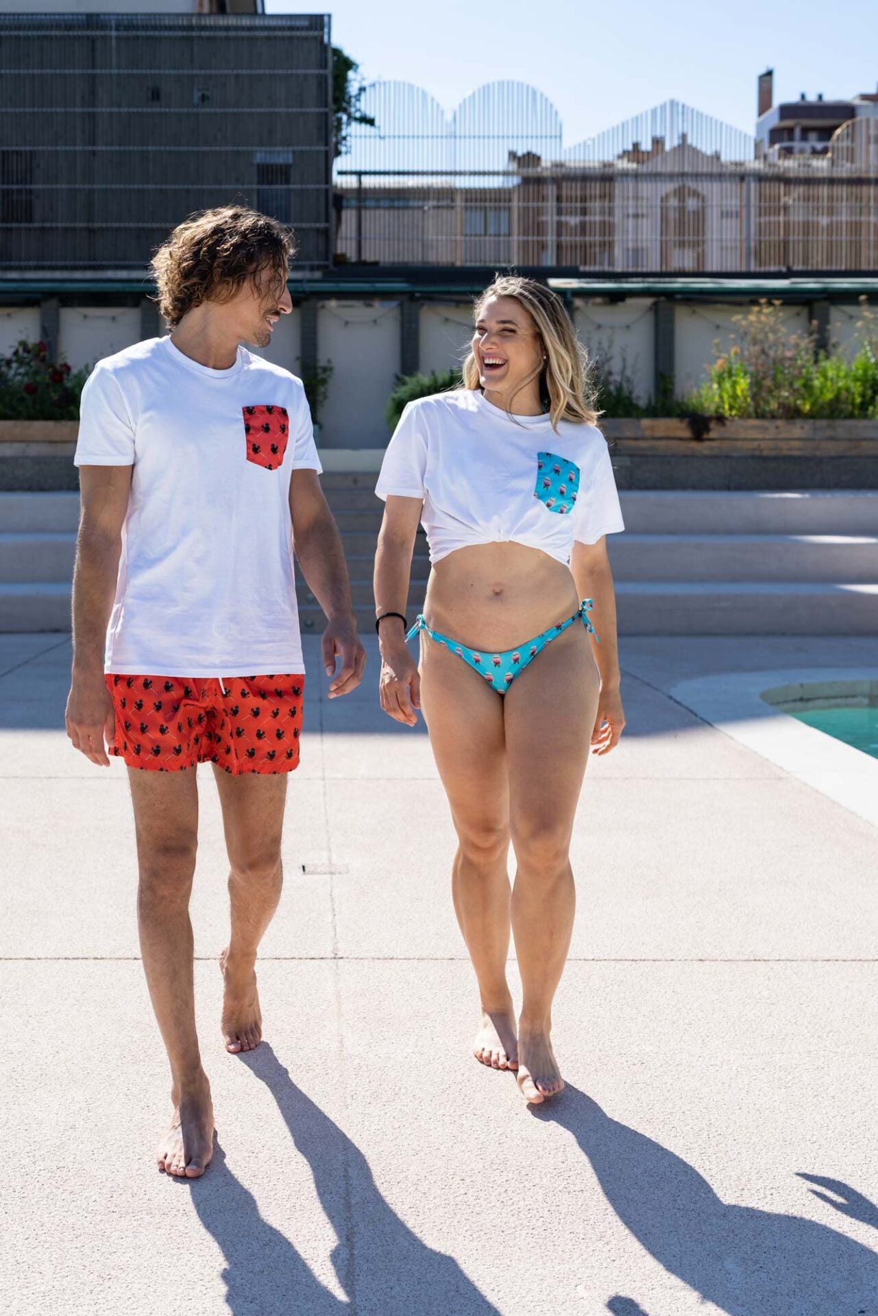 Two people walking by a pool with a cityscape in the background
Their swimsuits are made with econyl nylon