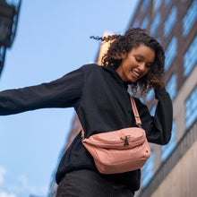 Charger l&#39;image dans la galerie, Woman carrying the Pacsafe Citysafe CX Anti-Theft Convertible Backpack color Rose made with ECONYL® regenerated nylon

