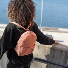 Charger l&#39;image dans la galerie, Woman travelling with the Pacsafe Citysafe CX Anti-Theft Convertible Backpack color Rose made with ECONYL® regenerated nylon
