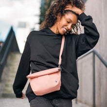 Charger l&#39;image dans la galerie, Woman carrying the Pacsafe Citysafe CX Anti-Theft Convertible Crossbody color Rose made with ECONYL® regenerated nylon
